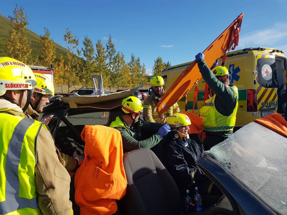 Sjúkraflutningamenn ásamt slökkviliðinu hlúa að nemanda í sviðsettu slysi