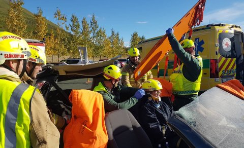 Sjúkraflutningamenn ásamt slökkviliðinu hlúa að nemanda í sviðsettu slysi